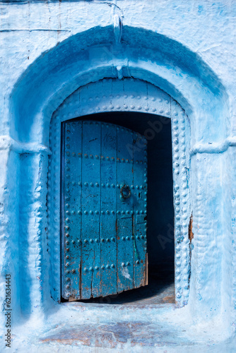 Vibrant blue colored wooden door in downtown Chefchaouen © imagoDens