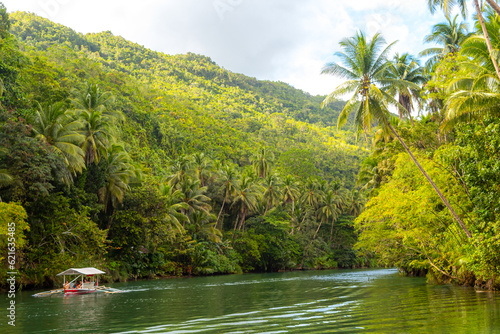 Exotic cruise boat with tourists on a jungle river Loboc, Bohol photo