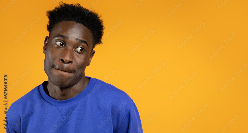 Desirous african american guy looking at copy space, yellow background Desirous african american guy looking at copy space, yellow background