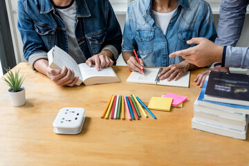 High school or college student group sitting at desk in library studying and reading, doing homework and lesson practice preparing exam to entrance, education concept