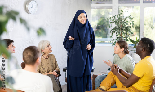 Foto Friendly young Asian woman in traditional Muslim dress with chador on head parti