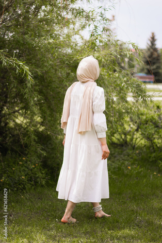 Portrait of A young Muslim woman in a white dress front of a tree. close plan. Pretty modest Muslim woman. European Muslim. tenderness. beauty. close plan.