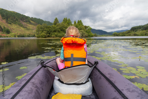 A young girl kayaking on a loch on a summers day in the Scottish Highlands 