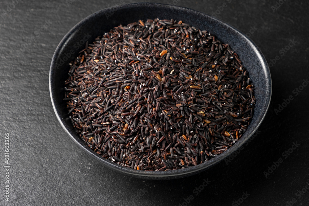 Black wild rice on black stone background