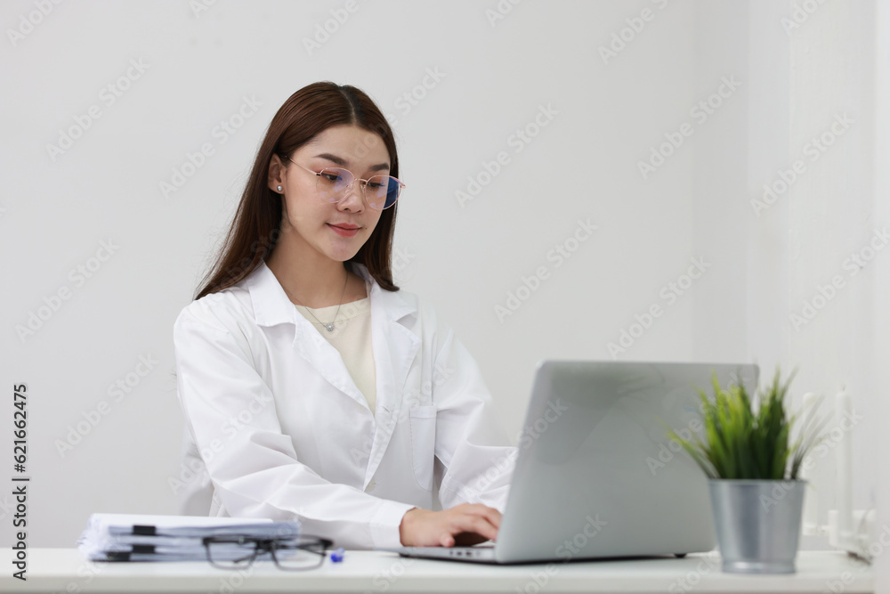 An attractive optometrist is working on the laptop in medical clinic An attractive optometrist is working on the laptop in medical clinic