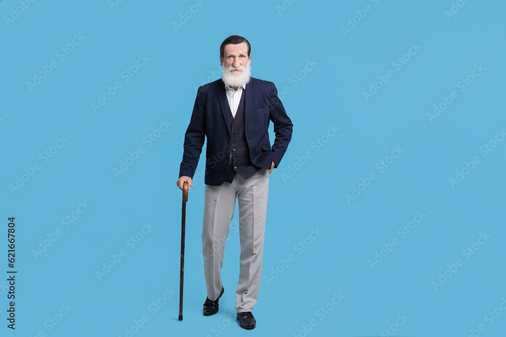 Senior man with walking cane on light blue background Senior man with walking cane on light blue background