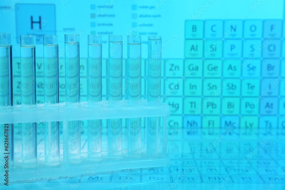 Fototapeta premium Test tubes against periodic table of elements, toned in light blue. Space for text