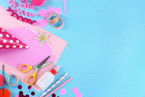 Flat lay composition with different materials to create party hats on light blue background, space for text. Handmade decoration © New Africa