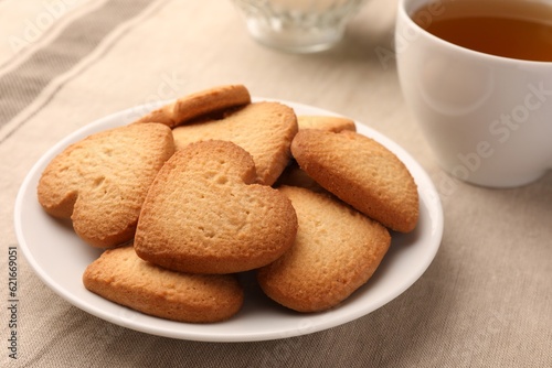 Heart shaped Danish butter cookies and tea on table, closeup
