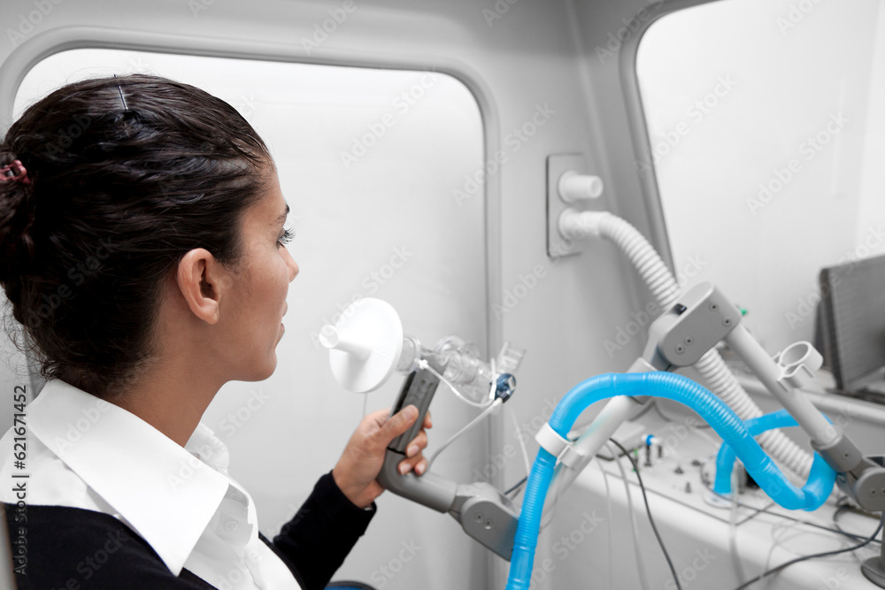 Young woman during a spirography test, measuring breathing movements with spirometer, spirometry