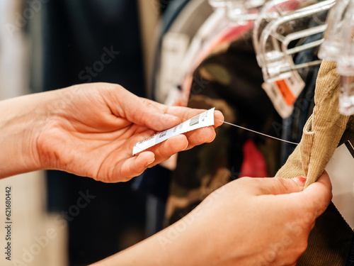 Female hand picking through clothes on a store rack