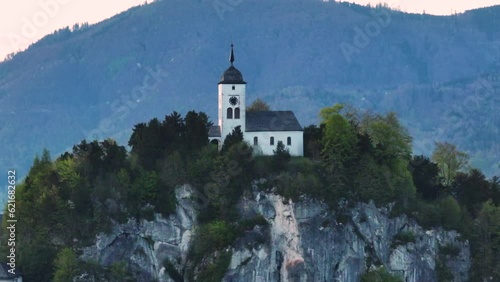 Drone Shot of Johannesberg Chapel on Rocky Hill Above Traunsee Lake and Traunkirchen Village, Austrian Alps photo