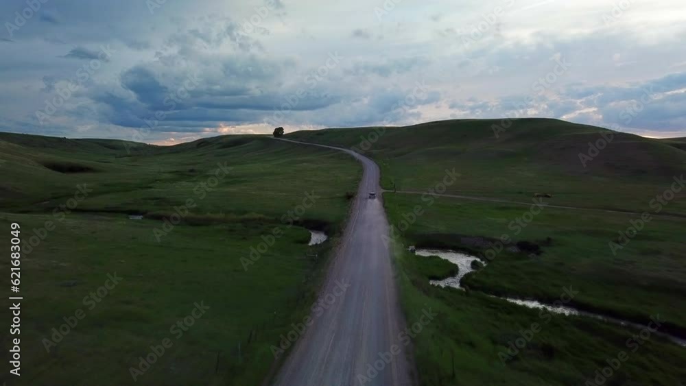 Aerial Forward Shot Of Vehicle Moving On Country Road Amidst Field Against Sky At Sunset - Billings, Montana Aerial Forward Shot Of Vehicle Moving On Country Road Amidst Field Against Sky At Sunset - Billings, Montana