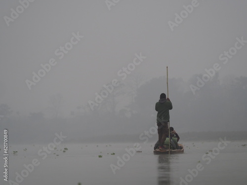 Man canoeing down river early morning
