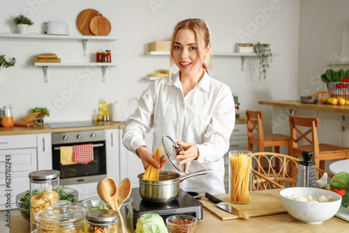 Young woman boiling spaghet...