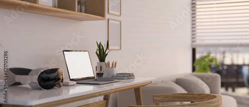 Fototapeta Naklejka Na Ścianę i Meble -  A laptop mockup, a modern VR headset on a table in a minimalist cozy living room.