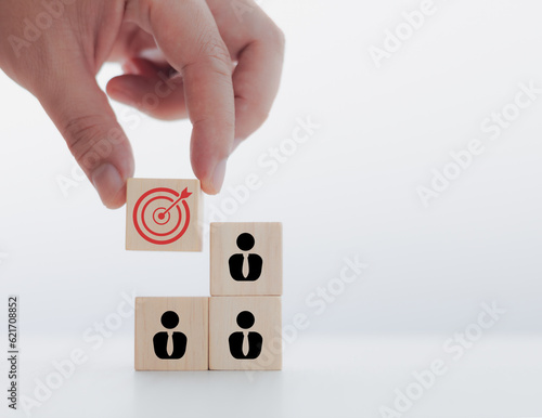 Customer relationship management concept, hand putting wooden blocks, target and people icons.