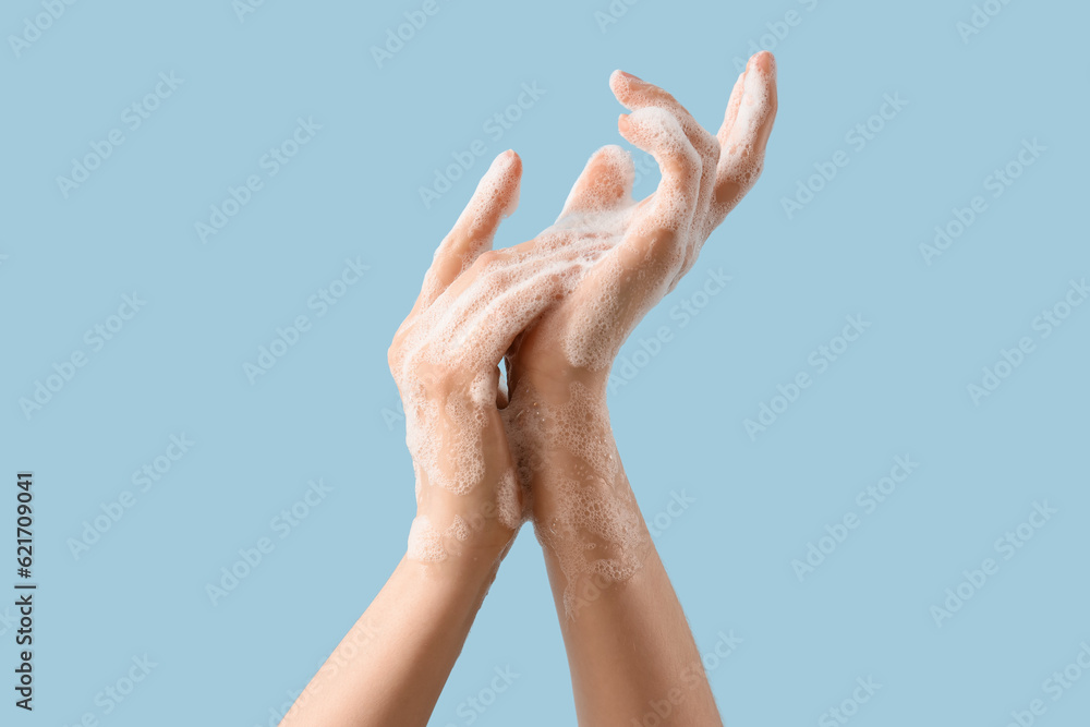 Hands in soap foam on light blue background Hands in soap foam on light blue background