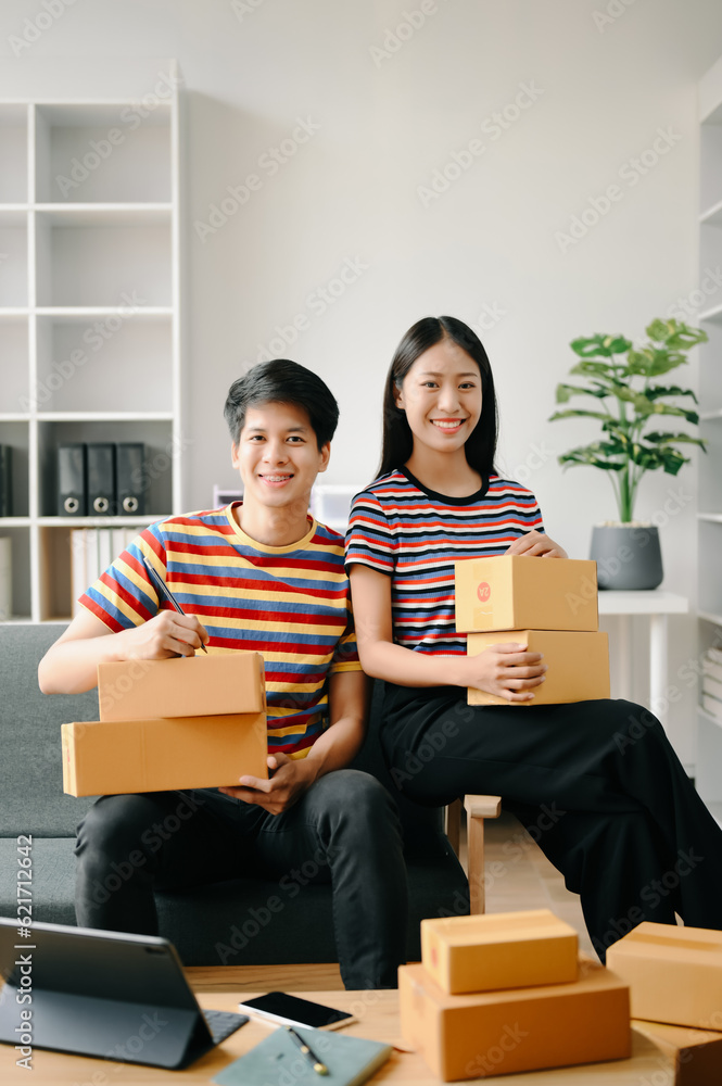 Starting small businesses SME owners, two check online orders Selling products working with boxs freelance work on sofa at home using tablet and laptop marketing, packaging, concept. Starting small businesses SME owners, two check online orders Selling products working with boxs freelance work on sofa at home using tablet and laptop marketing, packaging, concept.