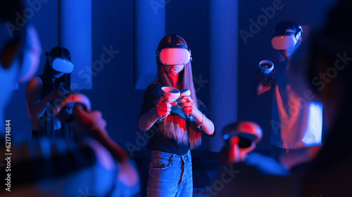 Obraz na płótnie A team of young friends using virtual reality VR equipment on a arena w salonie