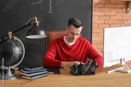 Focused young man writing n...