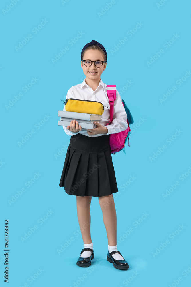 Little schoolgirl with backpack, pencil case and books on blue background Little schoolgirl with backpack, pencil case and books on blue background