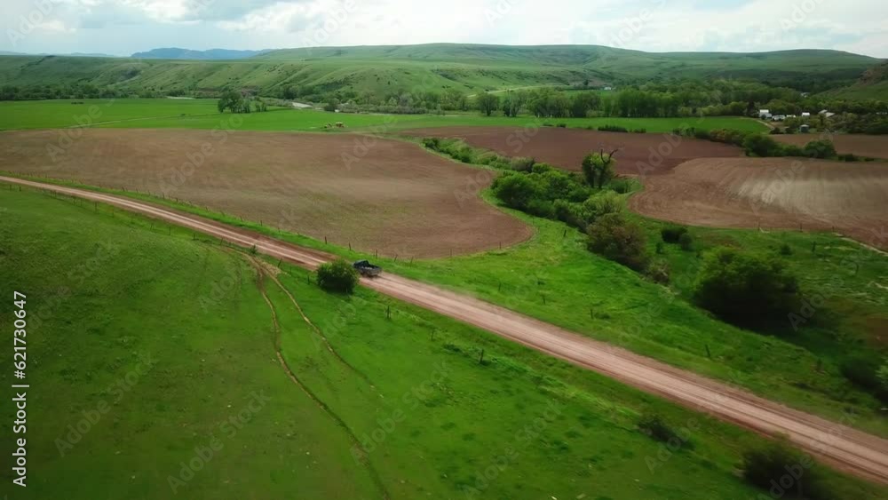 Aerial Descend Shot Of Pickup Truck Moving On Dirt Road Amidst Field - Billings, Montana Aerial Descend Shot Of Pickup Truck Moving On Dirt Road Amidst Field - Billings, Montana