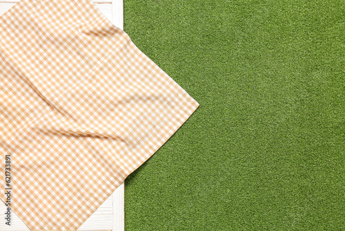 Schilderij op canvas Clean napkin on light wooden table against green grass background