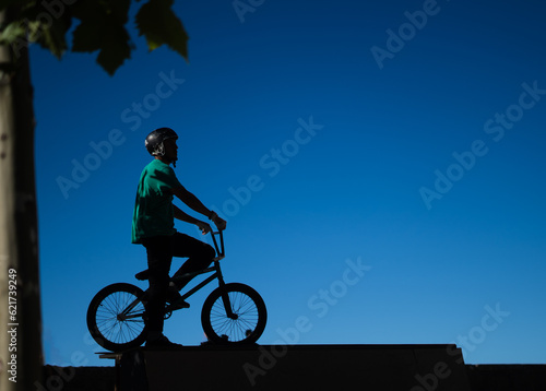 silhouette of a bmx rider on the top of a rump