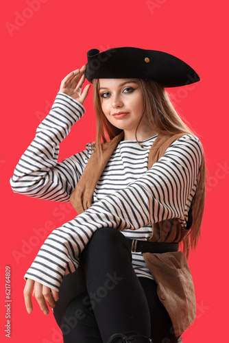 Beautiful female pirate on red background