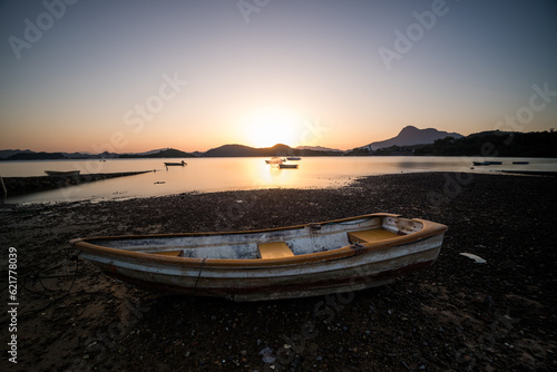 sunset on the beach with boat in foreground