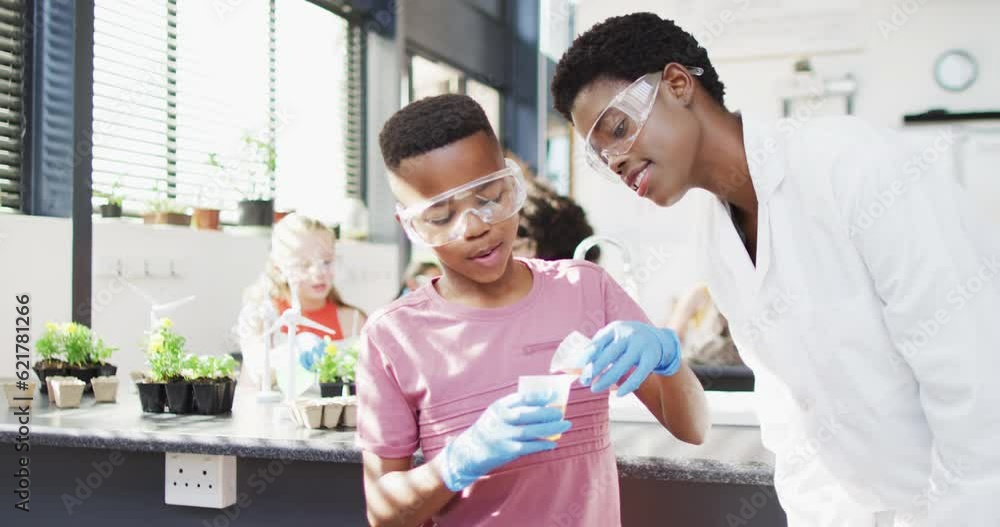 Diverse female teacher and happy schoolchildren having science class in school lab Diverse female teacher and happy schoolchildren having science class in school lab