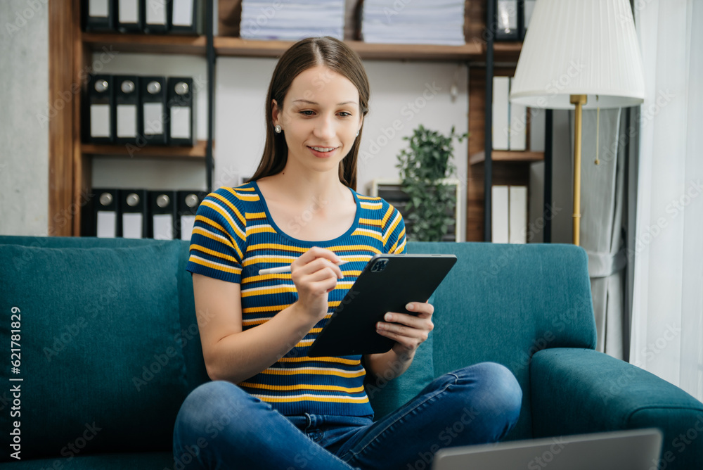 Caucasian businesswoman working in the office with working notepad, tablet and laptop documents on sofa in home office Caucasian businesswoman working in the office with working notepad, tablet and laptop documents on sofa in home office