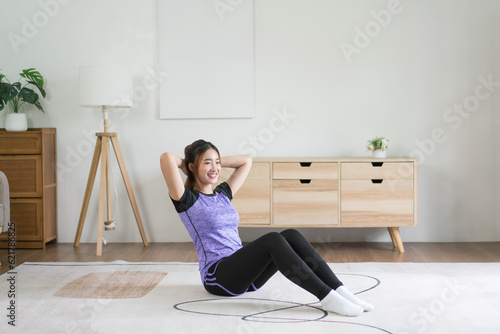 Young asian woman put hands behind head to doing exercise and workout for healthy lifestyle at home