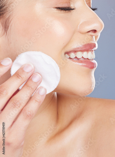 Skincare, cotton and woman woman in studio for makeup removal, toner or hydration on grey background. Smile, beauty and asian lady wellness model with facial pad for cleaning or glowing skin routine