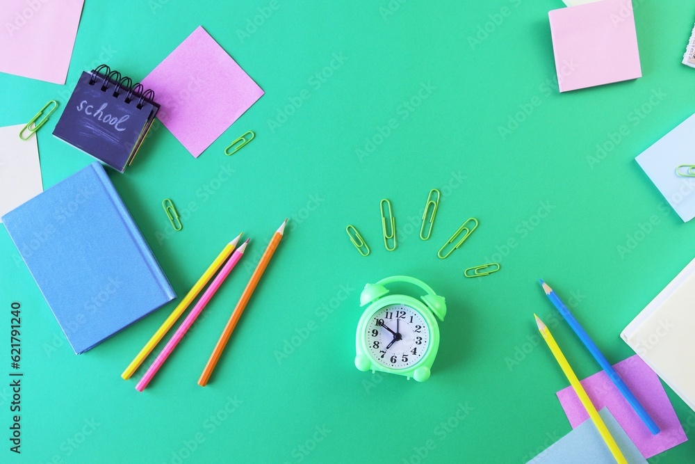 School supplies and an alarm clock on a green background. Back to school concept
School supplies and an alarm clock on a green background. Back to school concept