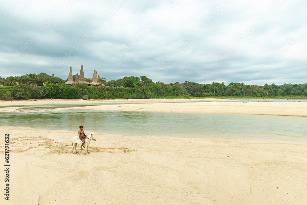Marapu Sumba Tribe gracefully rides a horse along the shoreline
