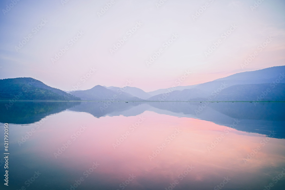 A Serene Panorama of Mountain Lake Reflecting on Water with a Pink Pastel Romantic Sky at Dusk