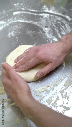 Close-up of a chef kneading pizza dough with his hands