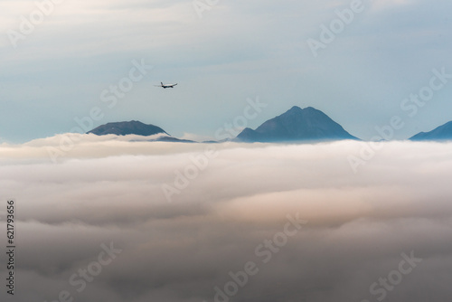 clouds over the mountains with small plane