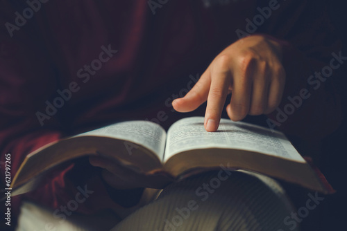 Christian man's hands while reading the Bible outside.Sunday readings, Bible education. spirituality and religion concept. Reading a book.education learning