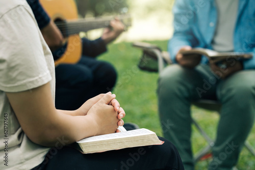 Christian Bible Study Concepts. Christian friend groups read and study the bible together in the park. sharing the gospel with a friend and holding each other\'s hand praying together. praying to God
