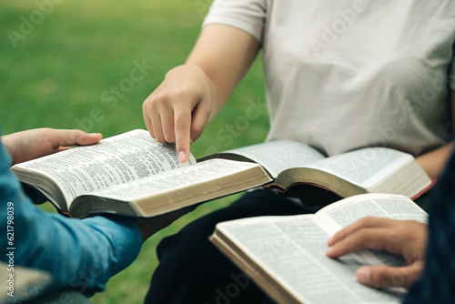 Christian group read and studied the bible at the park and prayed together. sharing the gospel with a friend. Holy Bible study reading together on Sunday. Study the Word Of God With Friends. Education