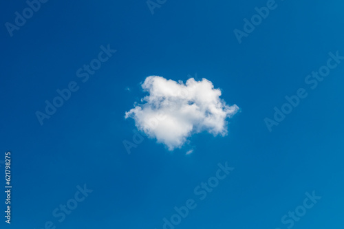 One little cloud on blue sky. Small, fluffy and lonely cloud for background with copy space