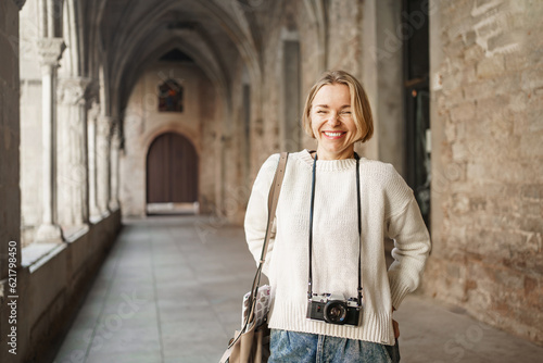 Canvas Print Young tourist photographer visiting ancient city - Smiling woman with camera enj