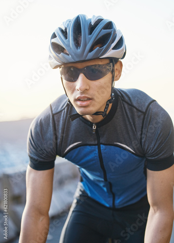 Man, mountain and cycling outdoor with sunglasses, helmet and speed for training, exercise and health in summer. Young cyclist athlete, focus and vision for race, performance and workout in sunshine