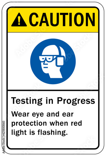 Testing in progress warning sign and labels wear eye and ear protection when red light is flashing
