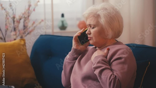 Stressed senior woman calling emergency services, suffering heart attack at home