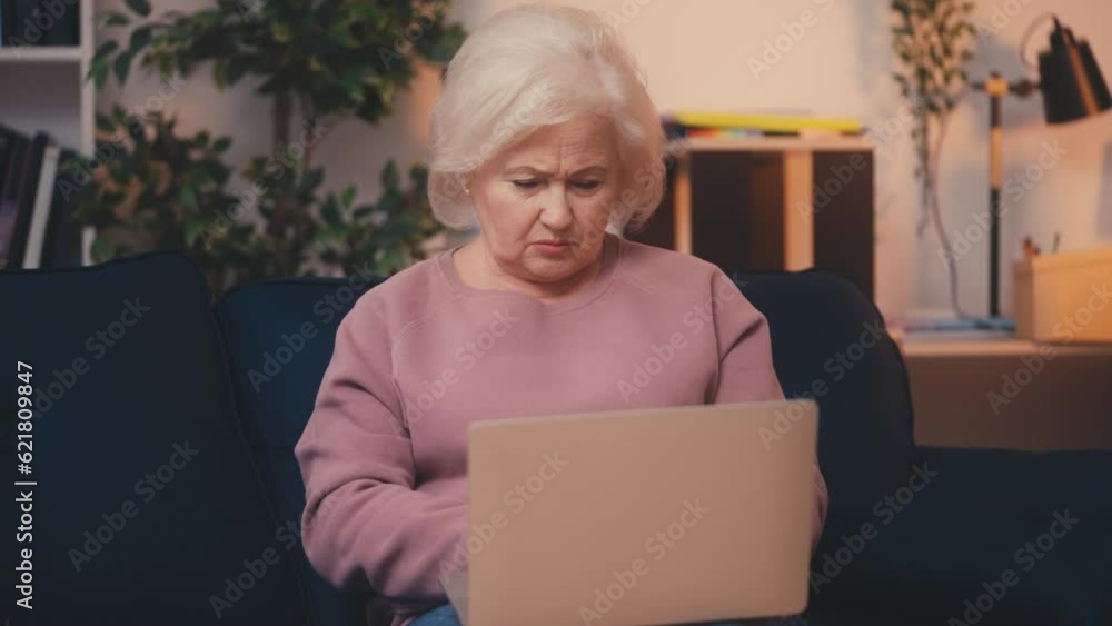 Senior woman having problems with her laptop, being hacked, computer virus Senior woman having problems with her laptop, being hacked, computer virus