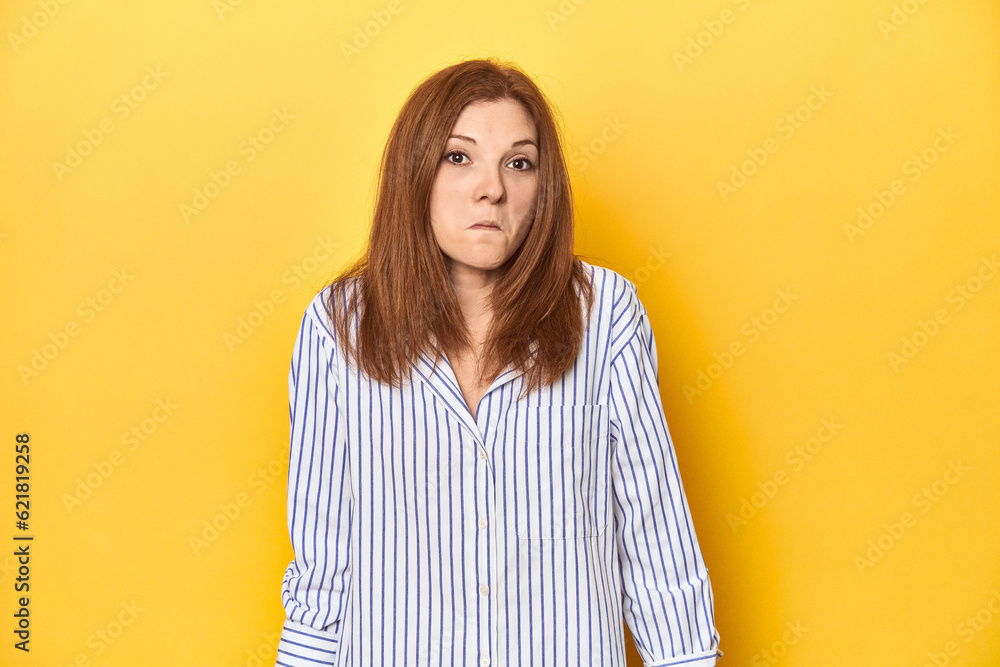 Business-dressed redhead, formal studio shot shrugs shoulders and open eyes confused. Business-dressed redhead, formal studio shot shrugs shoulders and open eyes confused.